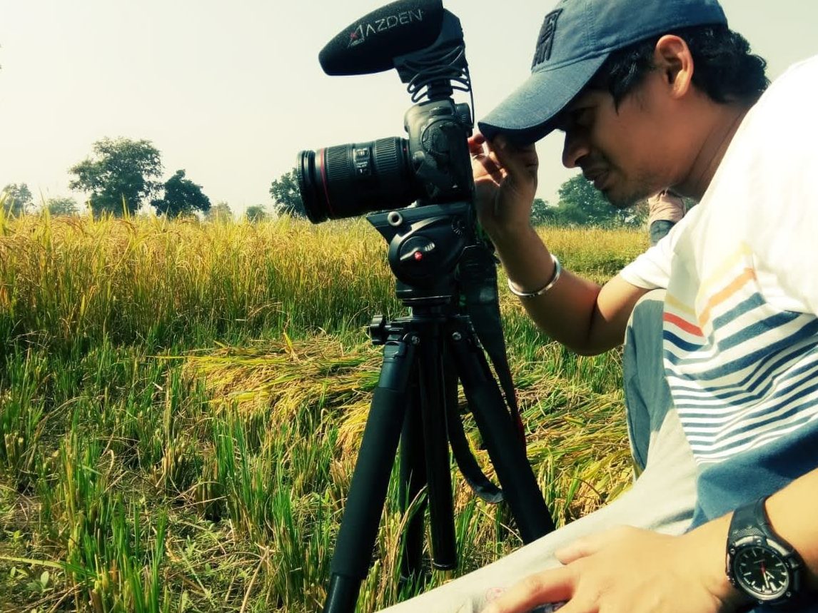 Jakesh Dalal framing a shot beside a rice field
